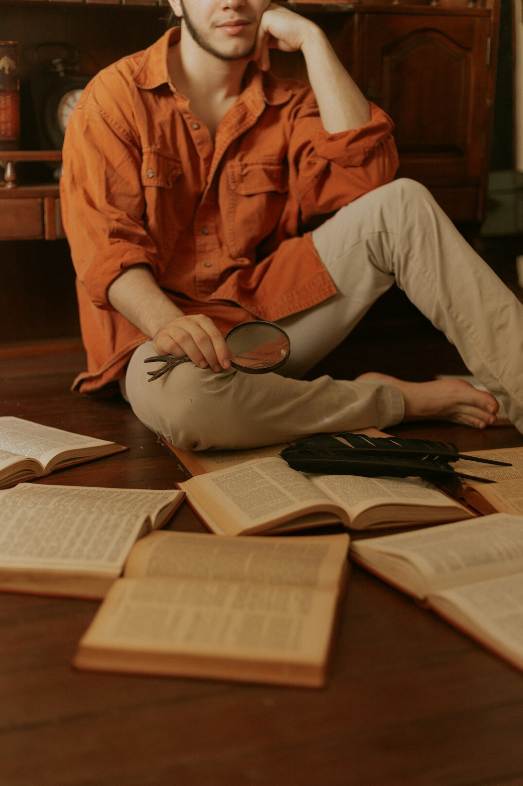 detective holding magnifying glass over book